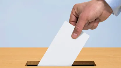 Elezioni - mano che inserisce scheda nell'urna